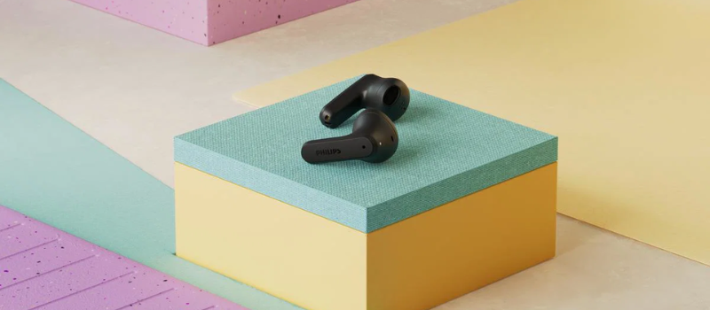 Pár černých True Wireless sluchátek Philips TAT2139 položený na barevném podstavci